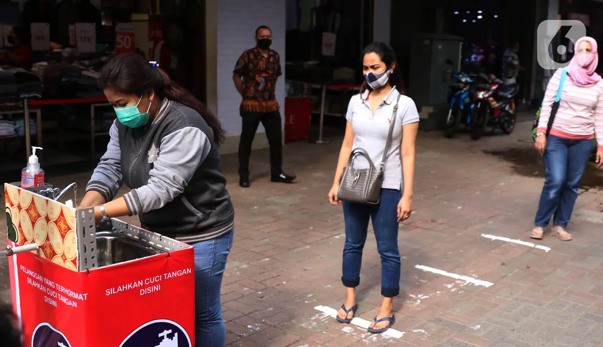 Pengunjung melakukan cuci tangan sebelum memasuki pertokoan di Pasar Baru (9/6/2020). Jelang pemberlakuan normal baru sejumlah toko di kawasan tersebut mewajibkan para pembeli untuk cuci tangan terlebih dahulu untuk menekan penyebaran Covid-19. (Liputan6.com/Angga Yuniar)