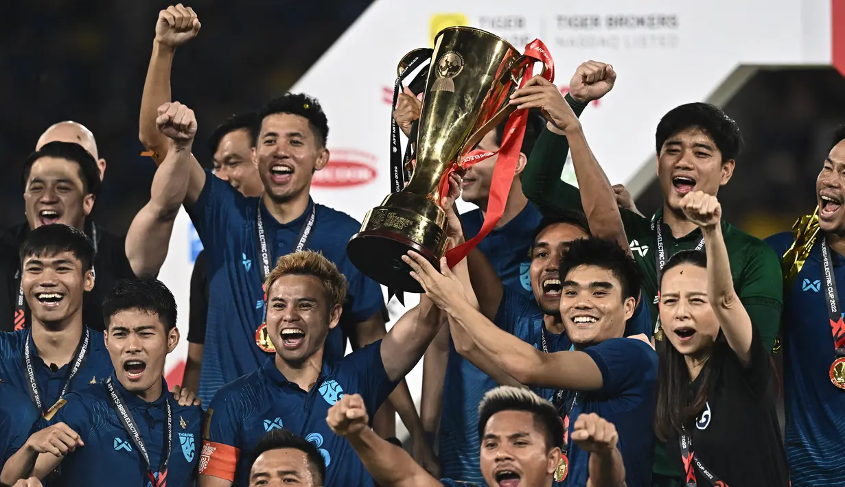 Timnas Thailand mengangkat trofi merayakan gelar juara Piala AFF 2022 usai menaklukkan Vietnam dalam laga final di Stadion Thammasat, Pathum Thani, Senin (16/1/2023). Thailand mempertegas status sebajai raja Asia Tenggara dengan menjuarai Piala AFF 2022. (Lillian SUWANRUMPHA / AFP)