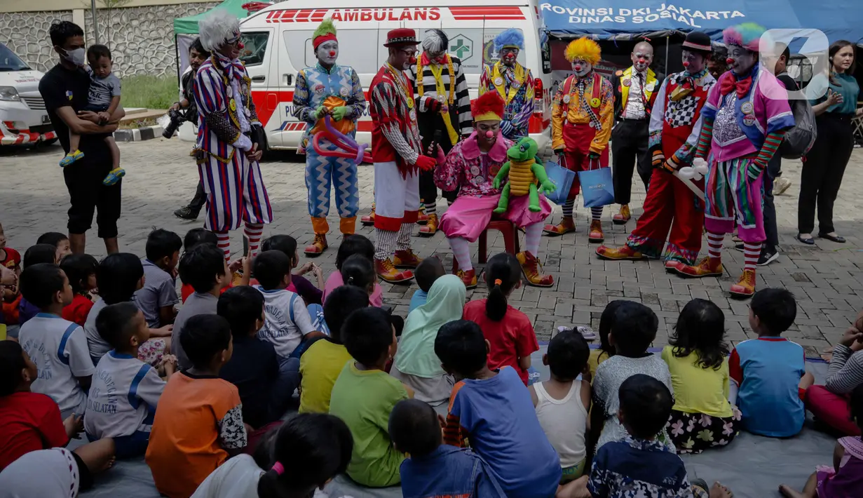 Anak-anak menyaksikan aksi badut yang tergabung dalam komunitas Aku Badut Indonesia (ABI) di pengungsian korban banjir di Gor Pangadegan, Jakarta, Selasa (7/1/2020). Trauma healing diberikan para badut sebagai bentuk kepedulian terhadap anak-anak korban banjir Jakarta. (Liputan6.com/Faizal Fanani)