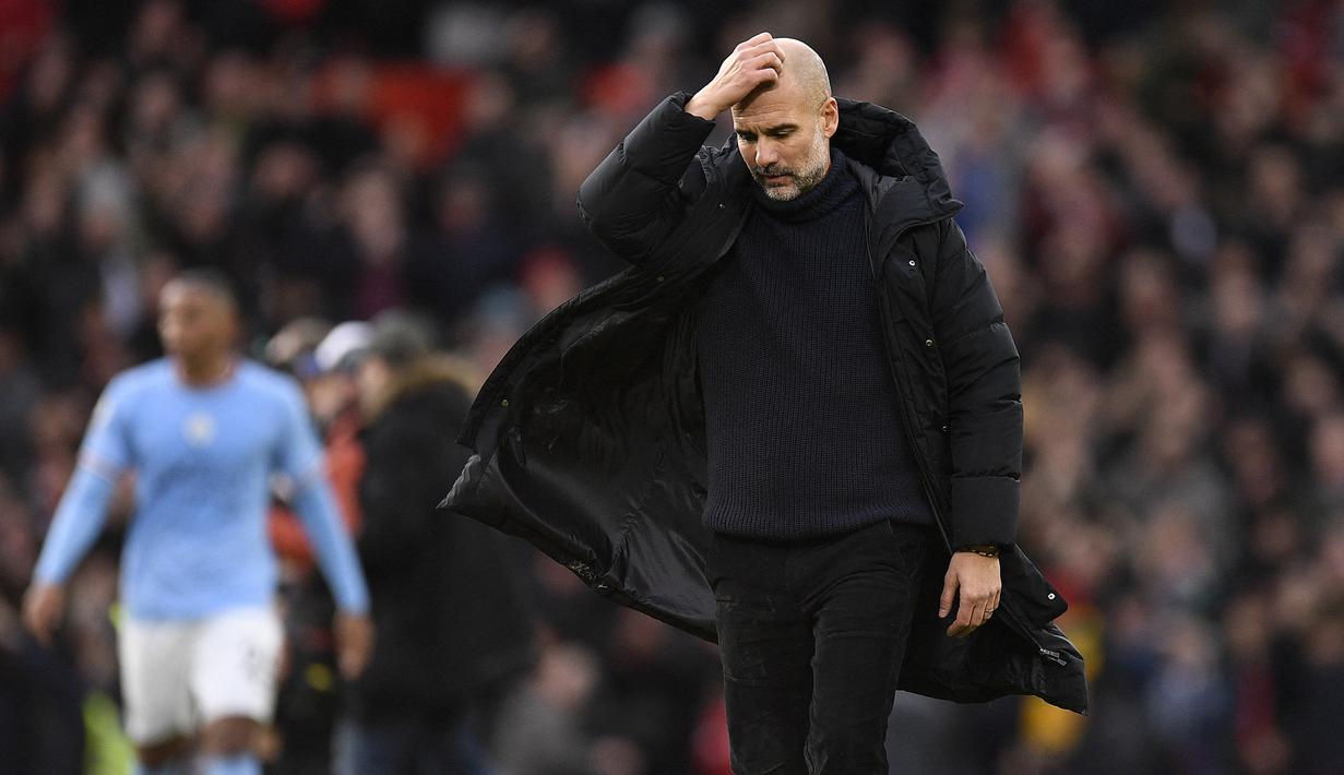 Pep Guardiola pun hanya bisa jalan tertunduk setelah pertandingan derby Manchester ini usai. (AFP/Oli Scarff)