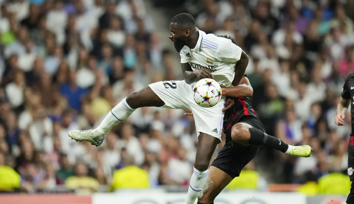 Bek Real Madrid Antonio Rudiger berebut bola dengan bek Red Bull Leipzig Abdou Diallo pada matchday 2 Liga Champions berlangsung di Santiago Bernabeu, Kamis (15/9/2022) dini hari WIB. Real Madrid menang susah payah 2-0 kala menjamu RB Leipzig. (AP Photo/Manu Fernandez)