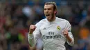 Penyerang Real Madrid, Gareth Bale melakukan selebrasi usai mencetak gol kegawang Rayo Vallecano pada lanjutan liga Spanyol di Santiago Bernabeu (20/12). Real Madrid menang telak atas Rayo Vallecano dengan skor 10-2. (AFP/curto DE LA TORRE)