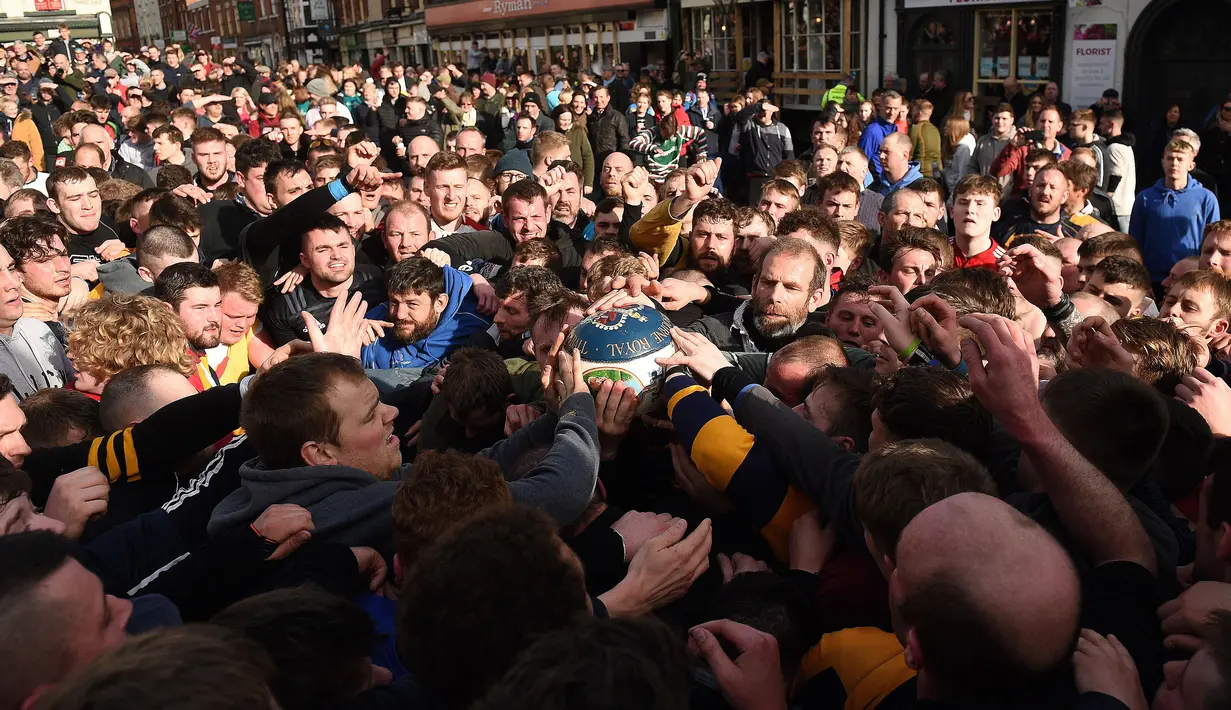 Para peserta berebut bola saat mengikuti Royal Shrovetide Football Match di Ashbourne, Derbyshire, Inggris, Selasa (5/3). Pertandingan ini terus dilaksanakan setiap tahun sebagai bagian dari festival. (Oli Scarff/AFP)