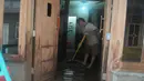 Seorang warga membersihkan rumah dari sisa-sisa genangan air yang merendam pemukiman mereka di kawasan Kampung Pulo, Jatinegara, Jakarta Timur, Selasa (10/2/2015). (Liputan6.com/Herman Zakharia)