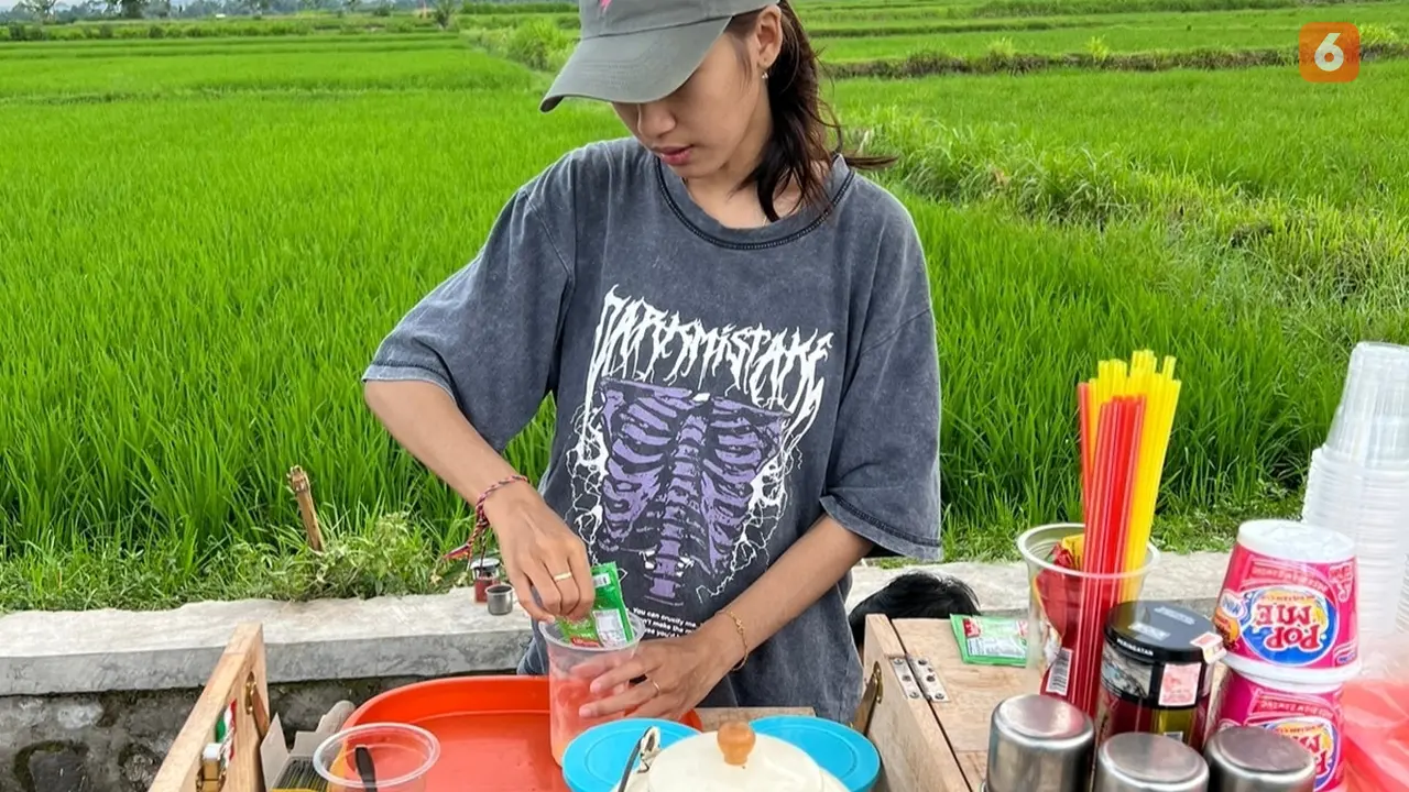 Anggel meracik kopi pesanan pelanggan di atas speda motor yang dimodifikasinya. (Hermawan Arifianto/Liputan6.com)