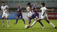 Pemain Rans Cilegon FC, Alfin Tuasalamony (kiri) berebut bola dengan pemain PSIM Yogyakarta, Sheva Maresca Amavisca dalam laga semifinal Liga 2 2021 di Stadion Pakansari, Bogor, Senin (27/12/2021). (Bola.com/Bagaskara Lazuardi)