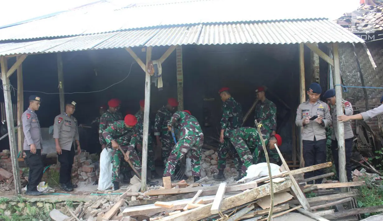 Prajurit Kopassus membersihkan puing-puing bangunan yang ambruk di Desa Citalahap, Kabupaten Lebak, Bogor (23/1). Sejumlah  bangunan rumah warga mengalami kerusakan cukup parah akibat gempa tersebut. (LIputan6.com/Pool/Kopassus)