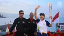Artis Olivia Zalianty membawa obor Asian Games 2018 berkeliling Danau Toba di Sumatra Utara, Rabu (1/8). Obor Asian Games itu akan di bawa berlayar dengan kapal hias di Danau Toba dan bersepeda menuju pantai bebas Danau Toba. (Liputan6.com/Reza Perdana)