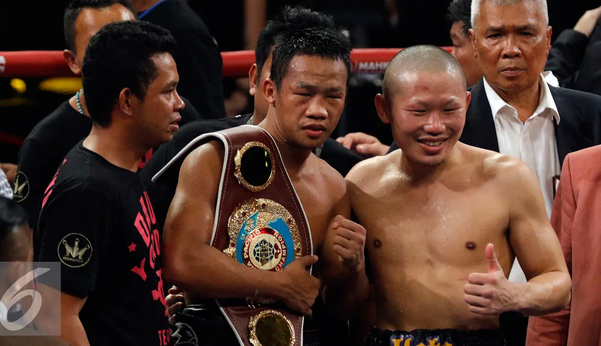 Daud Yordan (kiri) membawa sabuk juara tinju WBO (The World Boxing Organization) Asia-Pacific dan Africa disaksikan Yoshitaka Kato usai pertandingan bertajuk Road to the World Champions di Balai Sarbini, Jakarta, Jumat (5/2). (Liputan6.com/Johan Tallo)