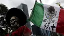 Seorang demonstran membawa bendera Meksiko selama protes hilangnya 43 mahasiswa di Meksiko (26/8/2015). Pemerintah Meksiko mengatakan 43 mahasiswa diculik oleh polisi dan diserahkan kepada anggota geng narkoba untuk membunuh mereka. (REUTERS/Henry Romero)