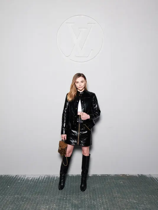 Chloe Grace Moretz memancarkan aura rocker dengan jaket kulit, rok mini zip-up kulit monogram, serta tas Reverse Monogram small trunk.  [Foto: Louis Vuitton].
