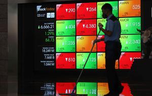 Aktivitas pekerja di depan layar Indeks Harga Saham Gabungan (IHSG) di BEI, Jakarta, Senin (3/1/2022). Pada pembukan perdagagangan bursa saham 2022 Indeks Harga Saham Gabungan (IHSG) langsung menguat 7,0 poin atau 0,11% di level Rp6.588,57. (Liputan6.com/Angga Yuniar)