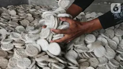 Pekerja mengangkat kerupuk kaleng di Depok, Jawa Barat. Pada musim penghujan jumlah kerupuk yang dibuat dan yang terjual relatif sama baik saat musim kemarau maupun hujan. (Liputan6.com/Fery Pradolo) 