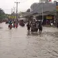 Ojek gerobak di Jalan Hasyim Ashari, Ciledug, Kota Tangerang, Banten saat banjir merendam. (Liputan6.com/Naomi Trisna)
