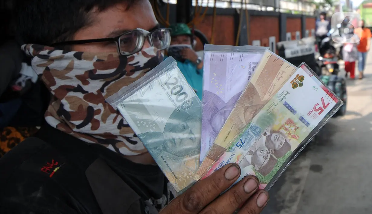 Penjual jasa penukaran uang menawarkan uang baru di kawasan Jalan Raya Parung, Bogor, Jawa Barat, Jumat  (7/5/2021). Penjual jasa penukaran uang memungut tambahan biaya sebesar 5 sampai 10 persen dari jumlah uang yang ditukarkan. (merdeka.com/Arie Basuki)