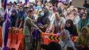 Untuk teknis pelaksanaannya masih sama seperti tahun-tahun sebelumnya, penerima cukup mengganti biaya administrasi kecil, namun bantuan diberikan sepenuhnya gratis. Tampak dalam foto, orang-orang mengantre untuk menerima barang-barang gratis seperti pakaian, bahan makanan pokok, dan perlengkapan rumah tangga yang disediakan oleh Asosiasi Organisasi Wanita (GOW) dan pemerintah daerah selama acara aksi sosial tahunan di bulan Ramadan, Surabaya pada Senin 2 Maret 2026. (JUNI KRISWANTO/AFP)