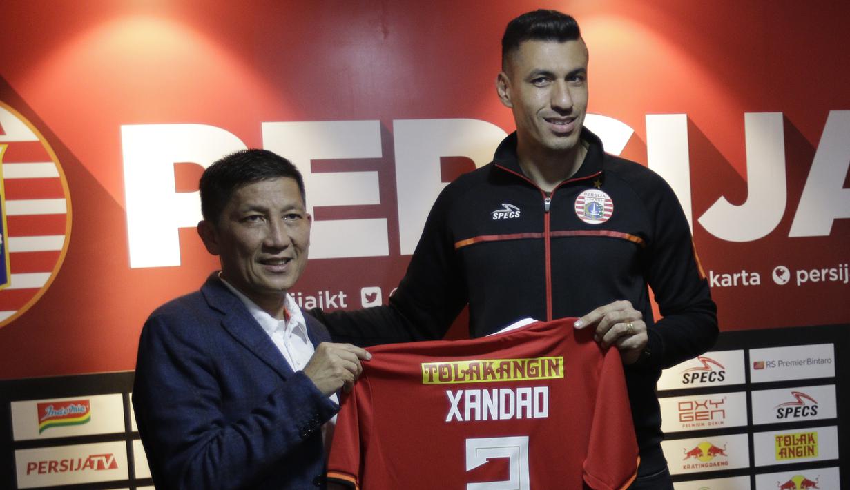 Pemain baru Persija Jakarta, Alexander Luiz Reame, menunjukan jersey yang akan digunakan nanti saat konferensi pers perkenalan dirinya di kantor Persija Jakarta, Jakarta, Jumat (30/8). Persija kenalkan pemain asing baru untuk mengarungi putaran 2 Liga 1. (Bola.com/Yoppy Renato)