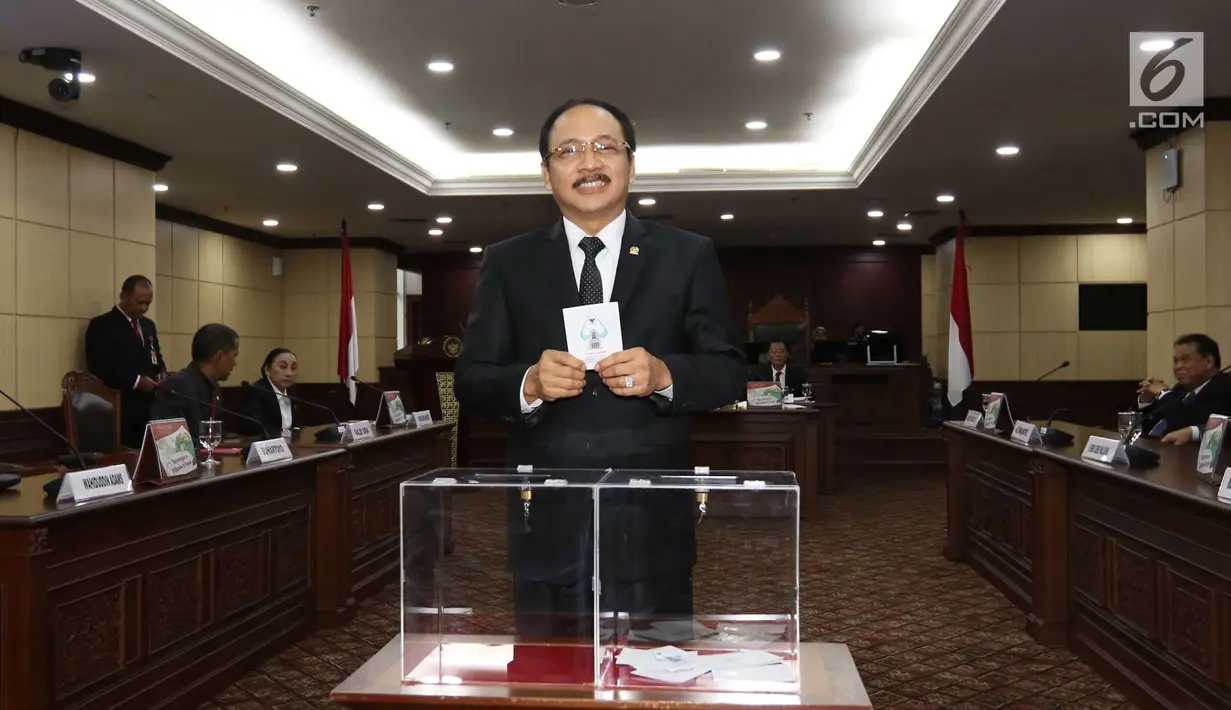 Hakim Konstitusi memasukkan surat suara saat pemilihan Ketua Mahkamah Konstitusi (MK) di Jakarta, Senin (2/3). Anwar Usman terpilih sebagai Ketua MK menggantikan Arief Hidayat. (Liputan6.com/Angga Yuniar)