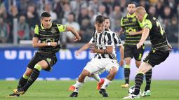 Striker Juventus, Paulo Dybala, berusaha melewati kepungan pemain Sporting Lisbon pada laga Liga Champions di Stadion Allianz, Turin, Rabu (18/10/2017). Juventus menang 2-1 atas Sporting. (AP/Alessandro Di Marco)