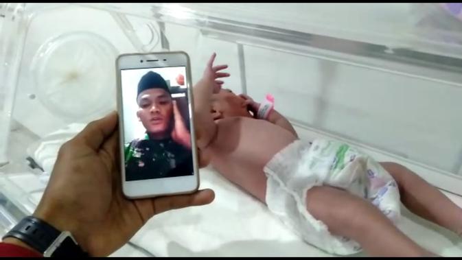 Praka Saiful Zuhri, prajurit Kostrad yang bertugas di Perbatasan RI-PNG mengazani kelahiran putrinya via video call. (Dokumen Puspen TNI)