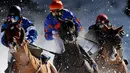 Para peserta saling memacu kudanya saat lomba flat race selama pacuan kuda White Turf di danau beku, Saint Moritz, Swiss, 17 Februari 2019. Pacuan kuda White Turf pertama kali diadakan pada 1907 oleh kaum bangsawan Eropa. (STEFAN WERMUTH / AFP)