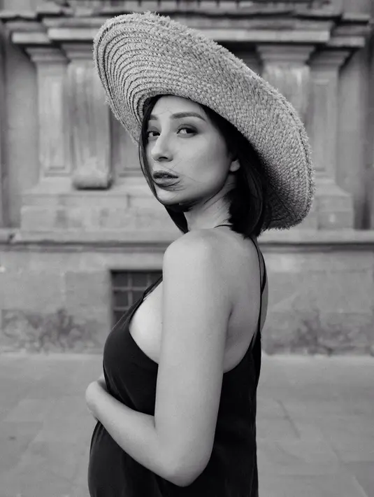 Topi fedora rajut menjadi salah satu fashion item yang manis untuk berlibur. Dipadukan dengan dress berwarna hitam, membuat aktris sekaligus presenter ini tampil lebih memesona.(Liputan6.com/IG/lolitagustine)