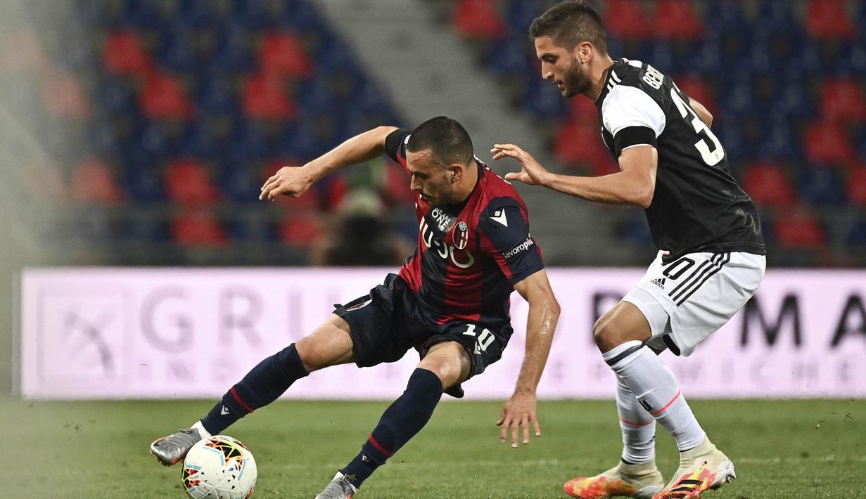 Pemain Juventus, Rodrigo Bentancur, berebut bola dengan pemain Bologna, Nicola Sansone, pada laga Serie A di Stadion Renato Dall'Ara, Senin (22/6/2020). Juventus menang 2-0 atas Bologna. (AP/Massimo Paolone)