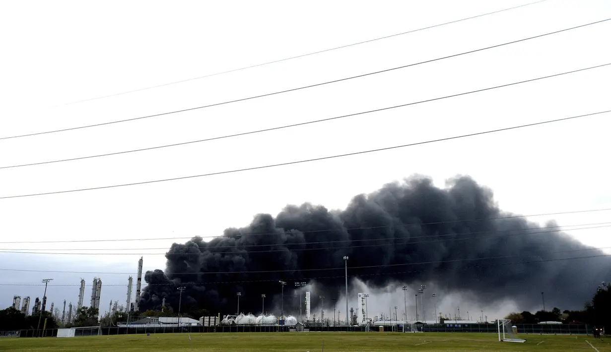 Asap tebal memenuhi langit di atas pabrik TPC saat api terus menyala setelah ledakan  Port Neches, Texas (27/11/2019). Pemadam kebakaran setempat masih mencoba memadamkan api dan meminta warga dalam radius 800 meter dari pabrik untuk dievakuasi. (Kim Brent/The Beaumont Enterprise via AP)