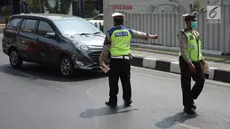 Petugas Kepolisian memberhentikan mobil berplat nomor genap yang memasuki persimpangan Jalan Dharmawangsa X dan Jalan Fatmawati, Jakarta, Senin (9/9/2019). Polisi mulai menindak pengendara yang melanggar perluasan ganjil genap di Jakarta Selatan. (Liputan6.com/Immanuel Antonius)