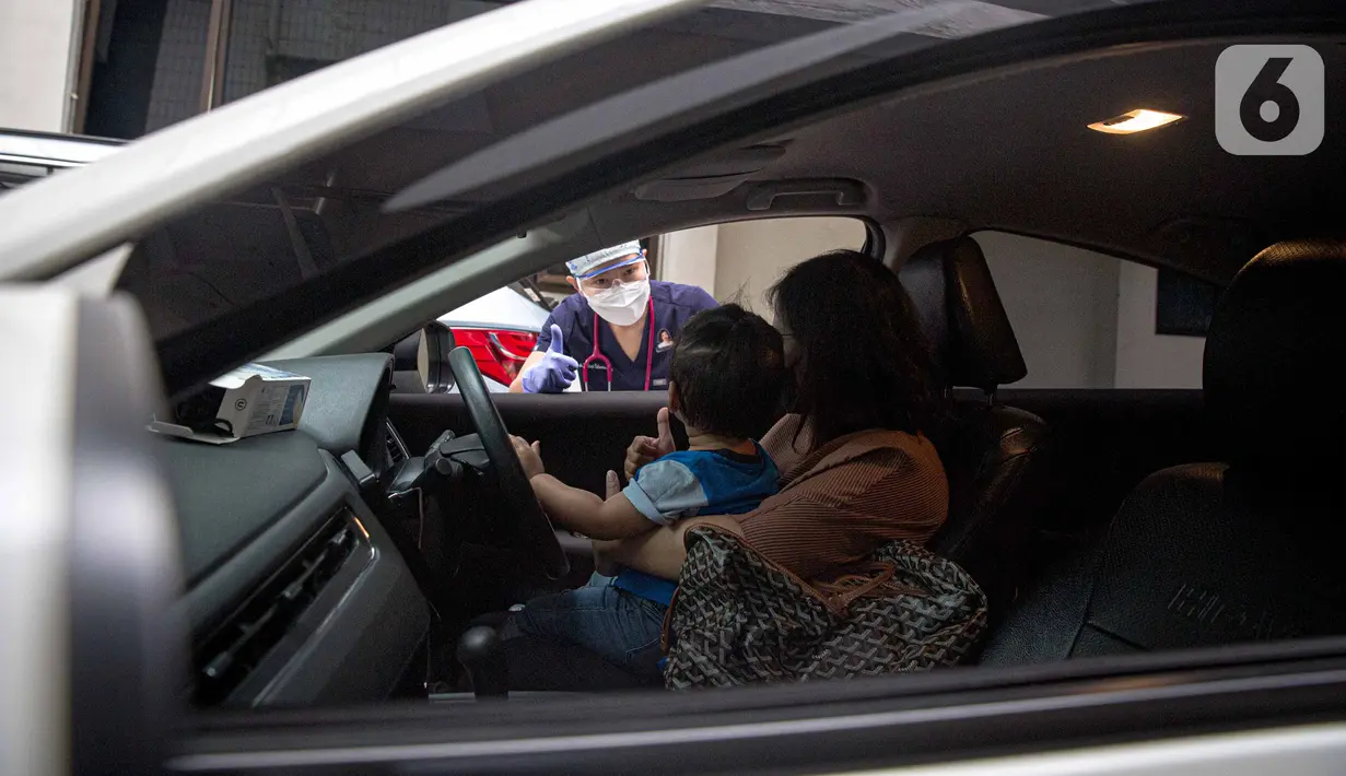 Petugas memeriksa kesehatan serta imunisasi pasien anak di RSIA Bunda, Jakarta, Jumat (18/3/2022). Pemeriksaan dilakukan drive thru guna memberi rasa aman orangtua, khususnya ibu yang ingin melaksanakan imunisasi serta pemeriksaan nonpenyakit di tengah pandemi COVID-19. (Liputan6.com/Faizal Fanani)