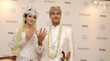 Pasangan Raisa Andriana dan Hamish Daud Wyllie menunjukkan cincin pernikahan usai jumpa pers di Ayana MidPlaza, Jakarta, Minggu (3/9). Raisa dan Hamish resmi menjadi pasangan suami istri pada 3 september 2017. (Liputan6.com/Herman Zakharia)