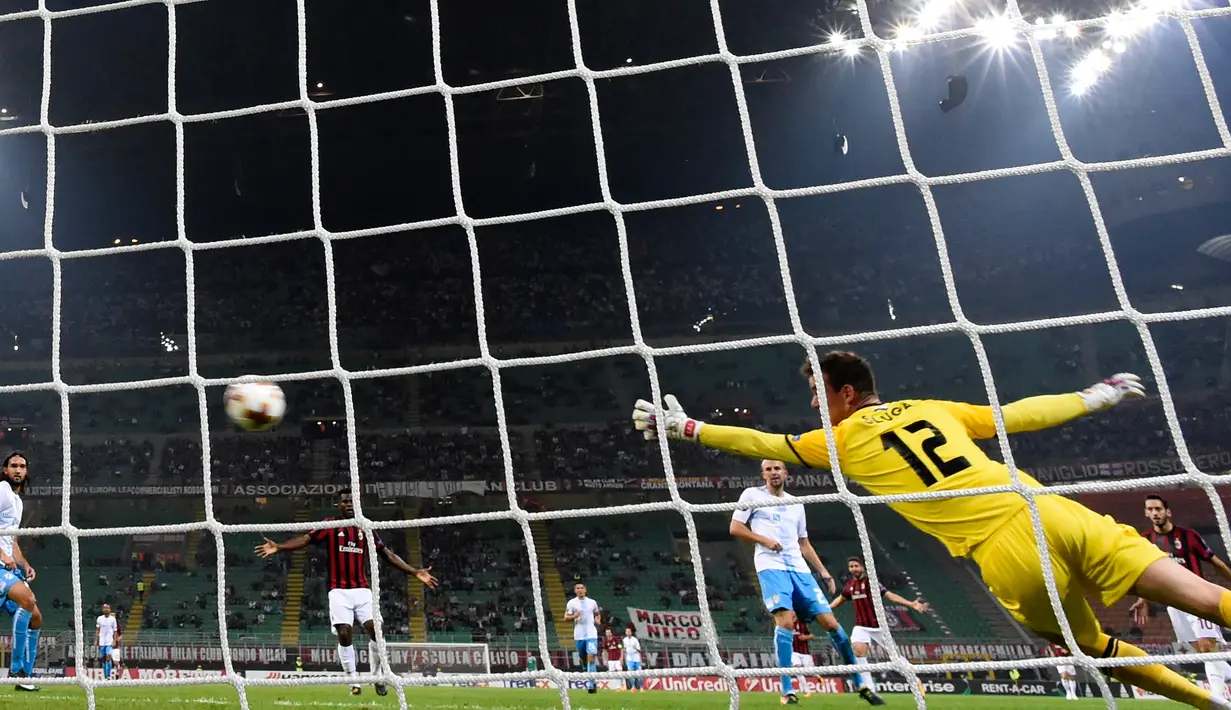 Kiper HNK Rijeka, Simon Sluga gagal menangkap bola yang ditendang oleh pemain AC Milan, Andre Silva dalam laga Grup D Liga Europa di San Siro, Kamis (28/9). Satu gol Andre Silva mewarnai kemenangan AC Milan 3-2. (MIGUEL MEDINA/AFP)