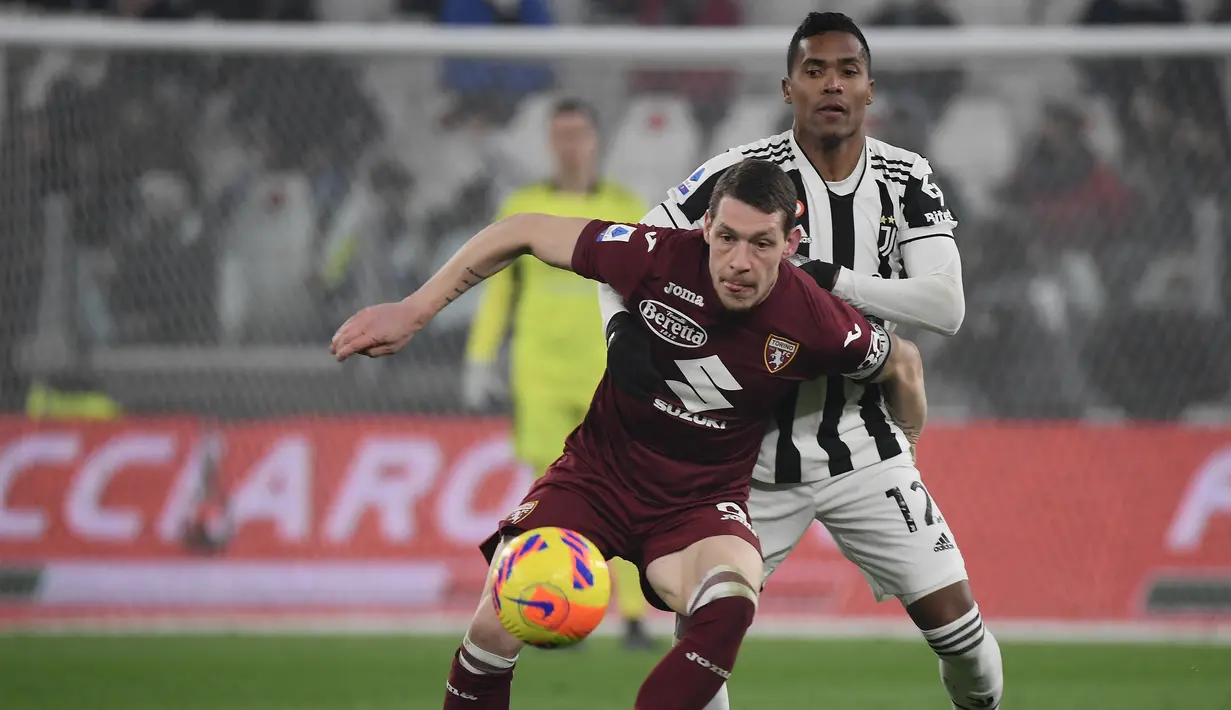 Penyerang Torino Andrea Belotti (kiri) berebut bola dengan bek Juventus Alex Sandro (kanan) dalam pekan 26 Serie A Liga Italia di Allianz Stadium, Sabtu (19/2/2022) dinihari WIB. Juventus ditahan imbang Torino 1-1. (Filippo MONTEFORTE / AFP)
