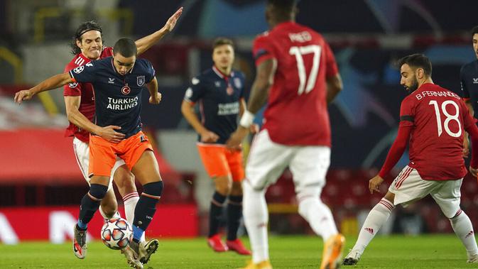 Striker Manchester United (MU) Edinson Cavani, berebut bola dengan pemain Istanbul Basaksehir, Rafael, pada laga Liga Champions di Stadion Old Trafford, Rabu (25/11/2020). Setan Merah menang dengan skor 4-1. (AP/Dave Thompson)