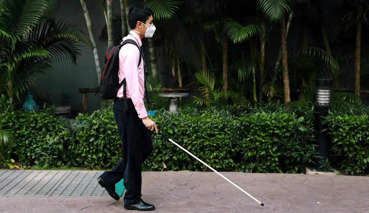 Seorang guru tunanetra, Damkerng Mungthanya berjalan menuju apartemennya di Bangkok, 12 Februari 2019. Setiap harinya, Damkerng bangun dan bepergian dengan kereta komuter dari pinggiran kota untuk menuju pusat Kota Bangkok. (REUTERS/Athit Perawongmetha)