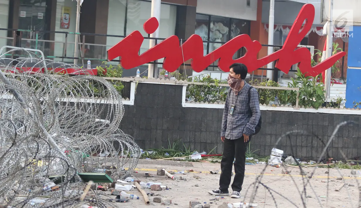 Seorang pria berdiri di depan gedung Sarinah, Jakarta, pascarusuh polisi dan massa, Kamis (23/5/2019). Kerusuhan di sekitar Bawaslu pada 22 Mei 2019 malam menyisakan kerusakan di berbagai titik, salah satu yang jadi korban adalah logo 'Sarinah' yang ikonik. (Liputan6.com/Herman Zakharia)