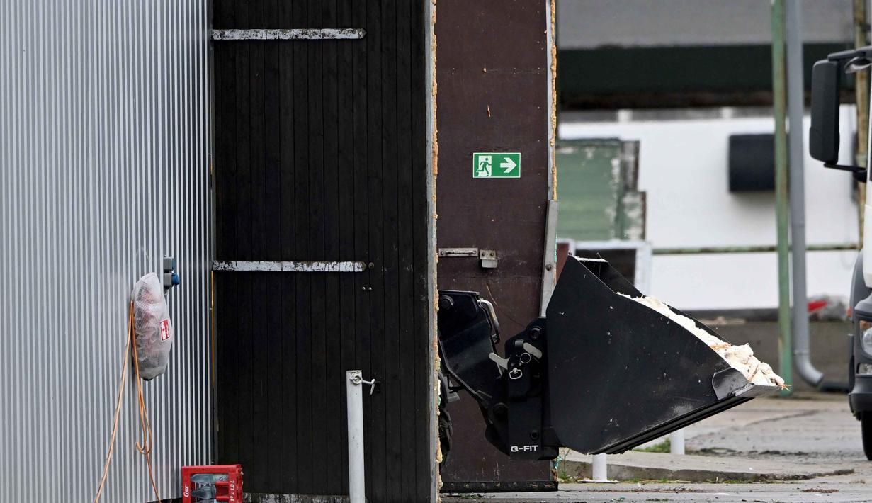 Unggas-unggas mati di dalam sekop wheel loader diangkut ke kandang setelah dimusnahkan di sebuah peternakan di Neutrebbin, Jerman, pada 27 Oktober 2025, di tengah wabah flu burung yang merajalela. (RALF HIRSCHBERGER/AFP)