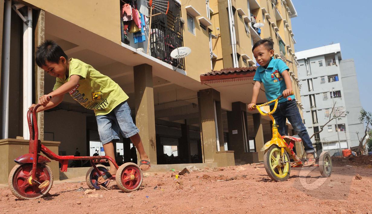Anak kecil bermain sepeda di halaman Rusunawa Muara Baru, Jakarta, Kamis (21/05/2015). Fasilitas rusunawa muara baru akan di tambah dan diperlengkap seperti pembangunan Ruang Publik Terpadu Ramah Anak (RPTRA). (Liputan6.com/Herman Zakharia)