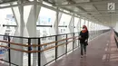 Warga melintasi jembatan penyeberangan (Skybridge) yang menghubungkan Stasiun LRT Velodrome dengan Halte Transjakarta Pemuda di Rawamangun, Jakarta, Senin (29/7/2019). Skybridge ini bertujuan memudahkan integrasi penumpang LRT menuju Transjakarta atau sebaliknya. (Liputan6.com/Immanuel Antonius)