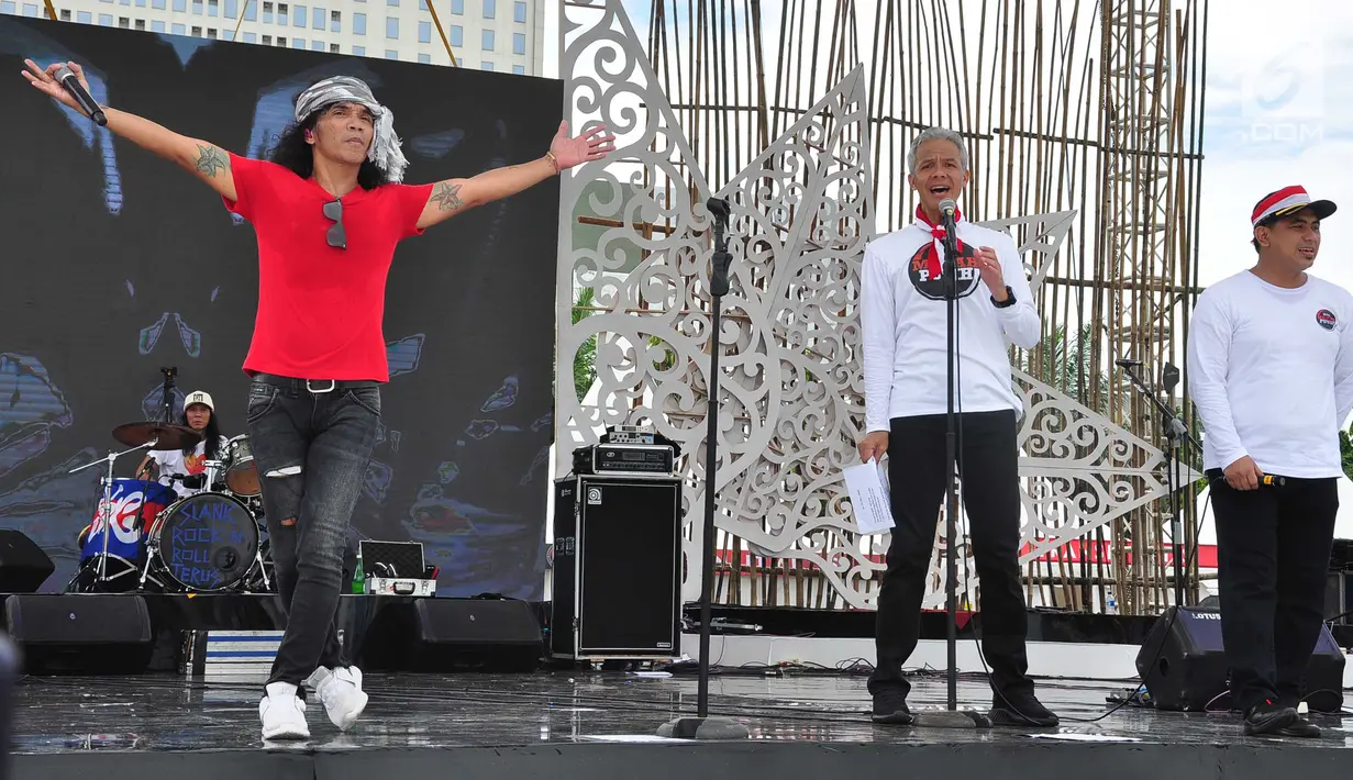 Grup band musik Slank duet dengan Gubernur Jawa Tengah, Ganjar Pranowo saat memeriahkan Apel Kebangsaan 'Kita Merah Putih' di lapangan Pancasila Simpang Lima Semarang, Minggu (17/3). (Liputan6.com/Gholib)