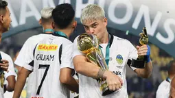 Pemain PSIM Yogyakarta, Rafinha mencium trofi Pegadaian Liga 2 2024/2025 setelah timnya berhasil menang atas Bhayangkara FC dalam laga final yang berlangsung di Stadion Manahan, Solo, Jawa Tengah, Rabu (26/02/2025). (Bola.com/Abdul Aziz)
