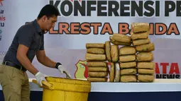 Petugas menata barang bukti berupa paket ganja sebelum rilis kasus di Banda Aceh, Aceh, Kamis (23/5/2019). Satresnarkoba Polresta Banda Aceh mengamankan satu ton paket ganja, tiga tersangka dan satu unit truk tronton saat akan membawa narkotika ke Jakarta. (CHAIDEER MAHYUDDIN/AFP)