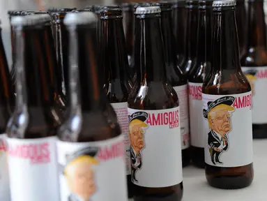 Sejumlah botol bir bergambar Presiden AS, Donald Trump di kemas di perusaahan Cru Cru Brewery di Mexico City (15/6). Botol bir ini labelnya bergambar Donald Trump dengan mengenakan pakaian bergaya Mariachi.  (AFP Photo/Bernardo Montoya)