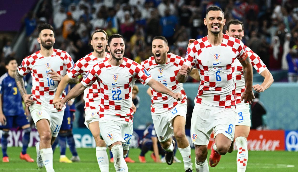 <p>Kiper Kroasia merayakan kemenangan setelah mengalahkan Jepang di babak adu penalti pada laga 16 besar Piala Dunia 2022 yang berlangsung di Al-Janoub Stadium, Senin (05/12/2022). (AFP/Jawel Samad)</p>