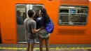 Dua calon penumpang yang hanya mengenakan celana dalam tampak menunggu kereta di stasiun kereta bawah tanah di Meksiko. Foto diambil Minggu (11/01/2015). (AFP PHOTO/RONALDO SCHEMIDT)