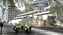 Patroli polisi bermotor melewati stan media, yang didirikan di luar Westminster Abbey menjelang akhir pekan penobatan Raja Charles III dan Ratu Camilla  di pusat kota London, Jumat (5/5/2023). (Photo by Oli SCARFF / AFP)