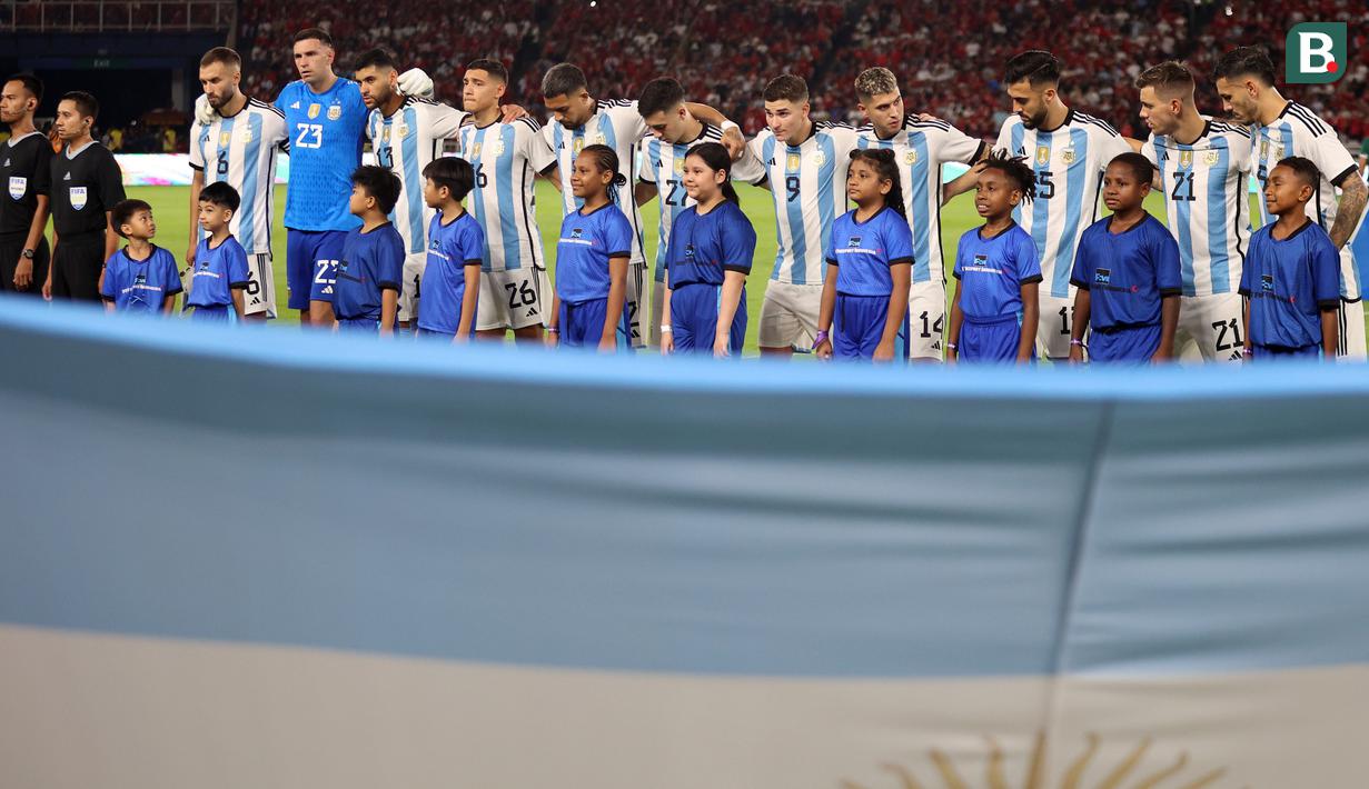<p>Cucu Presiden RI Joko Widodo, Jan Ethes (kiri bawah kedua) saat menjadi player escort kiper Timnas Argentina, Emiliano Martinez pada laga FIFA Matchday melawan Timnas Indonesia di Stadion Utama Gelora Bung Karno (SUGBK), Senayan, Jakarta, Senin (19/06/2023). (Bola.com/Bagaskara Lazuardi)</p>