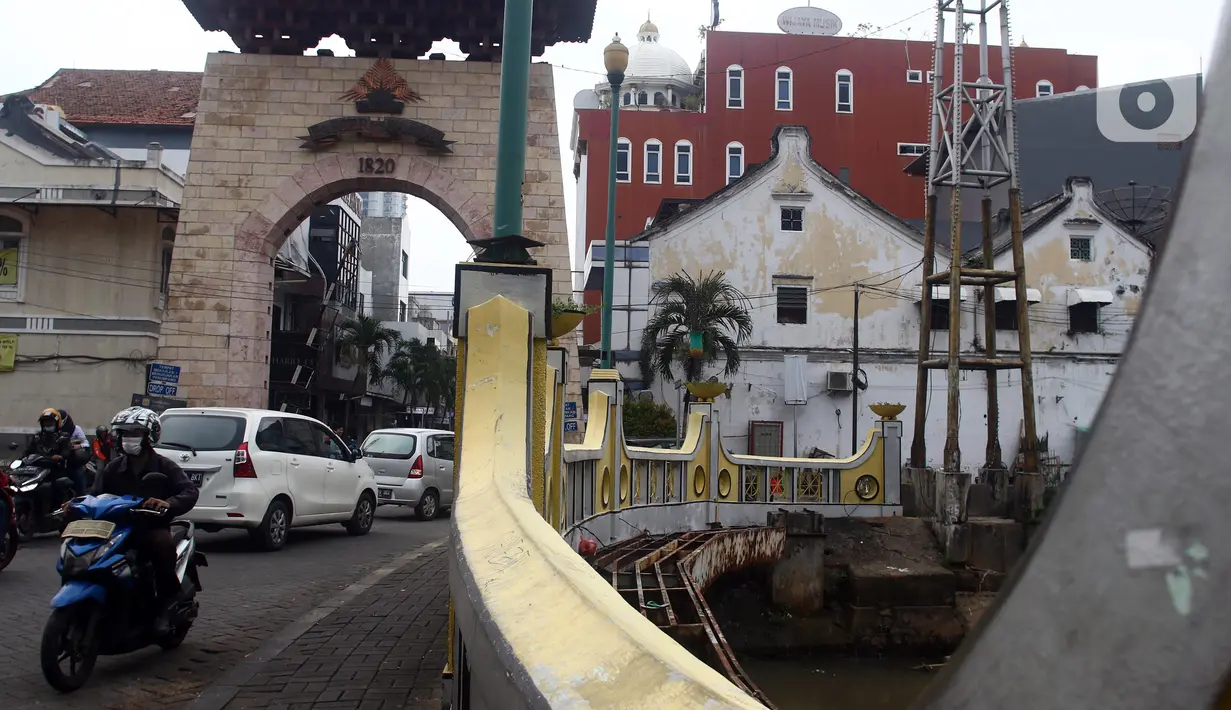 Aktivitas warga di jembatan penghubung depan gerbang kawasan Pasar Baru, Jakarta, Kamis (22/9/2022). Penetapan Kompleks Jalan Pasar Baru sebagai Kawasan Cagar Budaya pada Rabu (21/9/2022) dilakukan setelah proses kajian yang dilakukan oleh Tim Ahli Cagar Budaya (TACB) Provinsi DKI Jakarta serta ditetapkan melalui Keputusan Gubernur. (Liputan6.com/Helmi Fithriansyah)