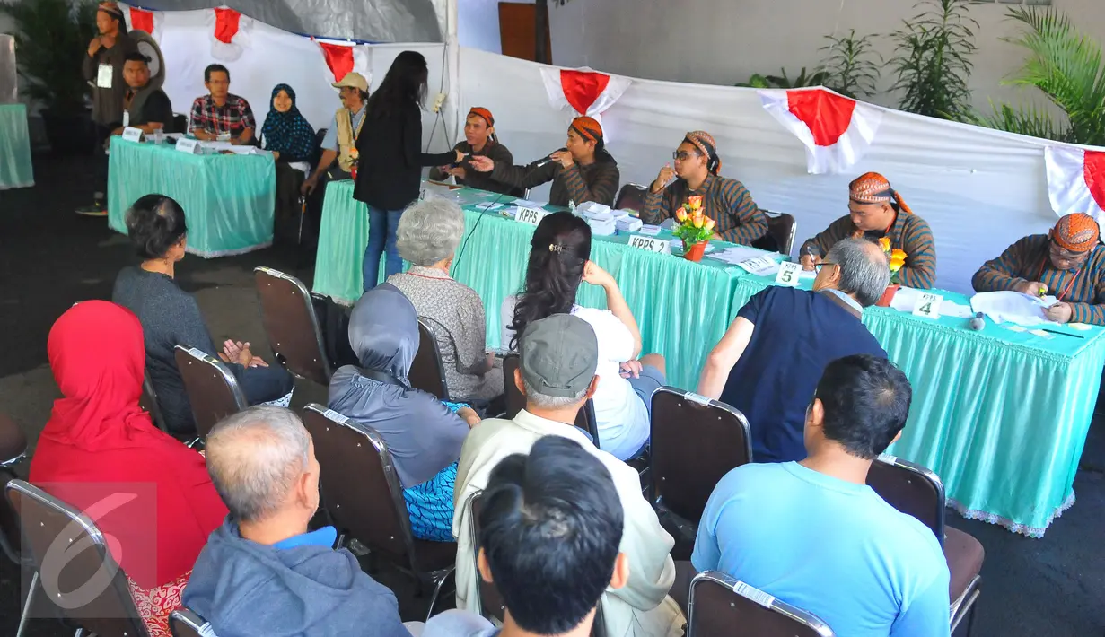 Petugas Kelompok Panitia Pemungutan Suara (KPPS) mengenakan pakaian tradisional khas Jawa dan blangkon di TPS 04 Gambir, Jakarta Pusat, Rabu (15/2). Penggunaan pakaian adat Jawa itu untuk memeriahkan gelaran Pilkada DKI 2017. (Liputan6.com/Angga Yuniar)