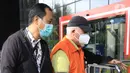 Bupati Banggai Laut, Sulawesi Tengah (Sulteng), Wenny Bukamo dikawal petugas saat tiba di Gedung Merah Putih KPK, Jakarta, Sabtu (5/12/2020). Wenny Bukamo terjerat Operasi Tangkap Tangan (OTT) KPK dalam dugaan kasus suap untuk kepentingan kampanye pemenangan. (Liputan6.com/Herman Zakharia)